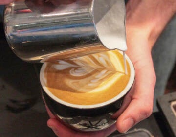 A close-up of a barista making latte art.