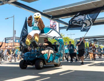 The Eagles mascot is seen on the front of a parade vehicle shaped like an Eagles helmet