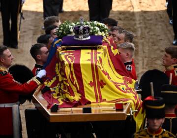 Pallbearers from the Queen's Company, 1st Battalion Grenadier Guards, prepare to carry the coffin of Queen Elizabeth II into Westminster Hall at the Palace of Westminster in London on Wednesday to lie in state following a procession from Buckingham Palace. Elizabeth's funeral is Monday. (Ben Stansall/Pool/AFP via Getty Images)