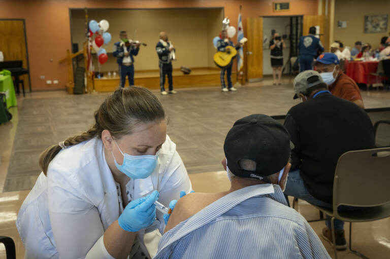 Pharmacist Patricia Pernal administers the newest COVID-19 vaccine during a clinic