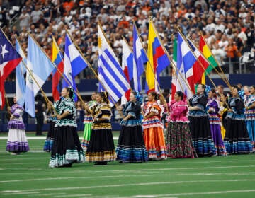 Women hold flags of Latin American countries.