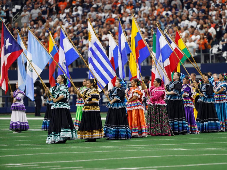 Women hold flags of Latin American countries.