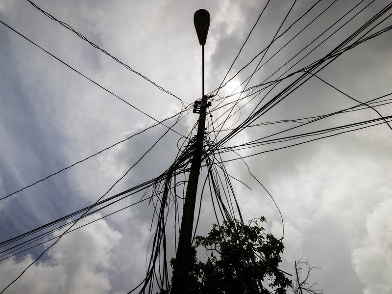 A utility pole with loose cables towers over the home of Jetsabel Osorio in Loiza, Puerto Rico