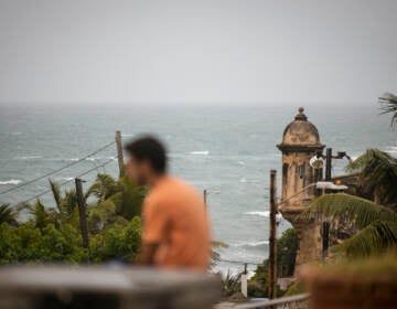 A man stands in front of a beach before the arrival of Tropical Storm Fiona in San Juan, Puerto Rico, Saturday, Sept. 17, 2022. Fiona was expected to become a hurricane as it neared Puerto Rico on Saturday, threatening to dump up to 20 inches (51 centimeters) of rain as people braced for potential landslides, severe flooding and power outages. (AP Photo/Alejandro Granadillo)