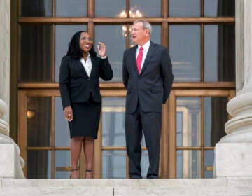 Justice Jackson stands to the left of Justice Roberts outside of a building.