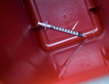 In this Tuesday, July 3, 2018, photo, a used syringe is seen in a disposal container. (AP Photo/Mary Altaffer)