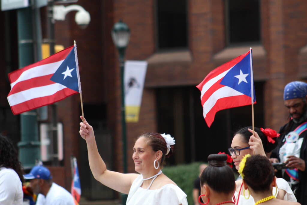 A woman holds up a Puerto Rican flag.