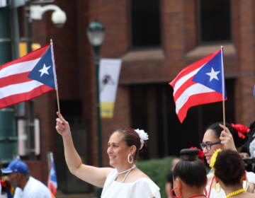 A woman holds up a Puerto Rican flag.