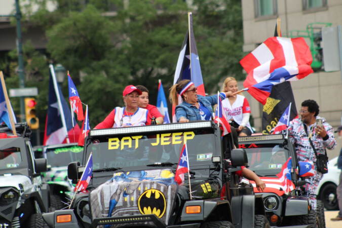 A group of people in jeeps waving the Puerto Rican flag.