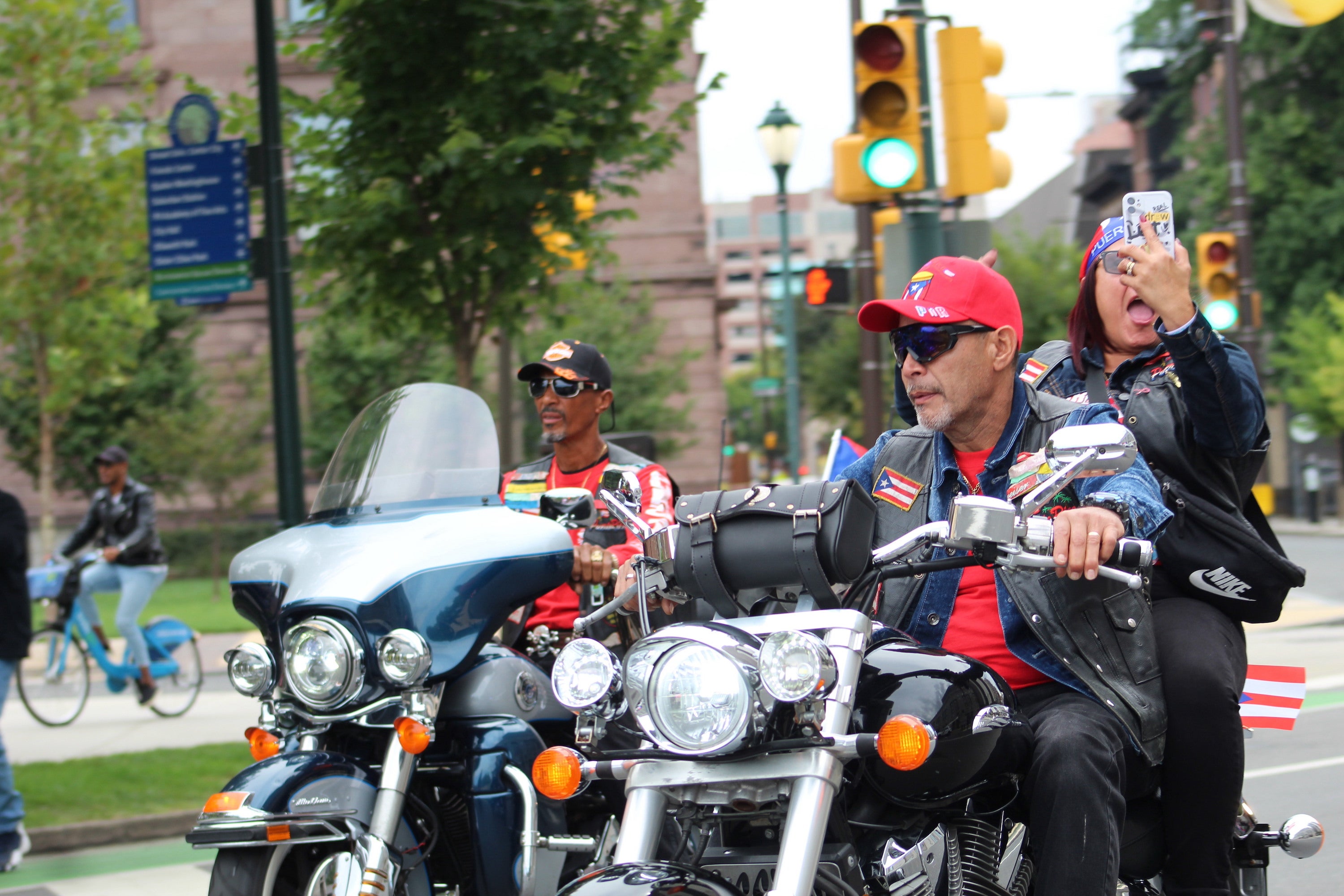 A group of people are on motorcylces with Puerto Rican flags visible.