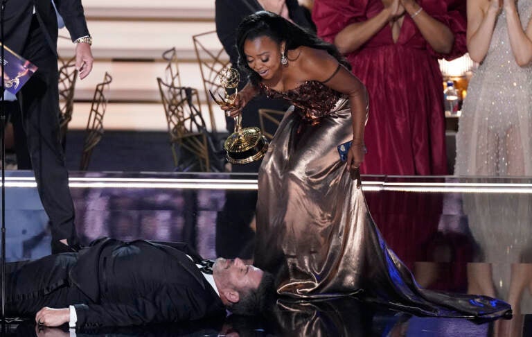 Quinta Brunson checks on Jimmy Kimmel as he lays on stage at the 74th Primetime Emmy Awards