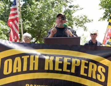 Stewart Rhodes speaks in front of a banner that reads, ''Oath Keeperes'