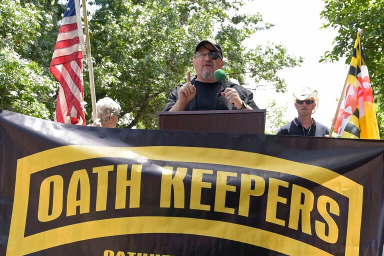 Stewart Rhodes speaks in front of a banner that reads, ''Oath Keeperes'