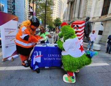Gritty and the Phillie Phanatic filling out their voter registration forms on September 20, 2022. (Tom MacDonald / WHYY)
