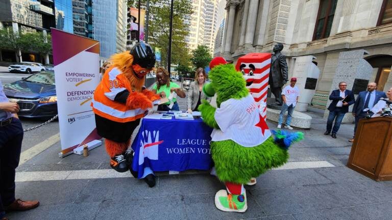 Gritty and the Phillie Phanatic filling out their voter registration forms on September 20, 2022. (Tom MacDonald / WHYY)