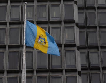 The Philadelphia flag waves outside the city’s Municipal Services building. (Kimberly Paynter/WHYY)