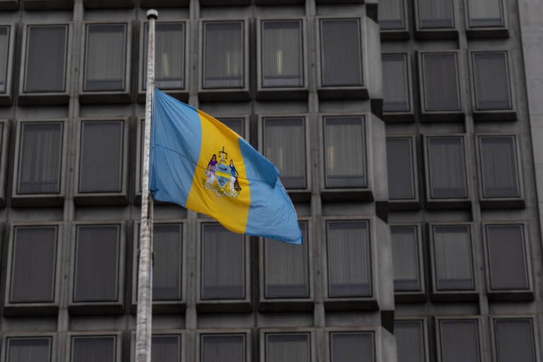 The Philadelphia flag waves outside the city’s Municipal Services building. (Kimberly Paynter/WHYY)