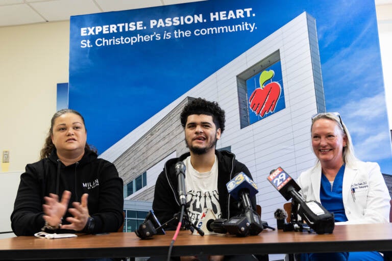 Mom Natali Rosario (left), 17 year-old Ivan (center) and pediatric neurosurgeon Dr. Tina Loven (right) spoke to the media about Ivan’s recovery a year after he was shot in the head near his high school, October 18, 2022. (Kimberly Paynter/WHYY)