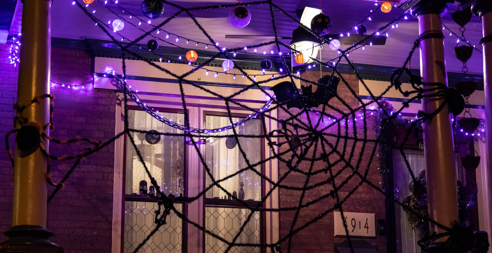 A spider web is seen hanging from a Halloween porch display in West Philly