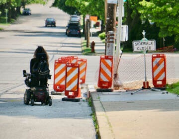 Anomie Fatale maneuvers around the closed sidewalk at the intersection of Port Royal and Henry avenues. The construction blocked her only safe route to the CVS near her home. (Emma Lee/WHYY)