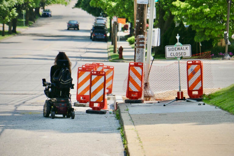 Anomie Fatale maneuvers around the closed sidewalk at the intersection of Port Royal and Henry avenues. The construction blocked her only safe route to the CVS near her home. (Emma Lee/WHYY)