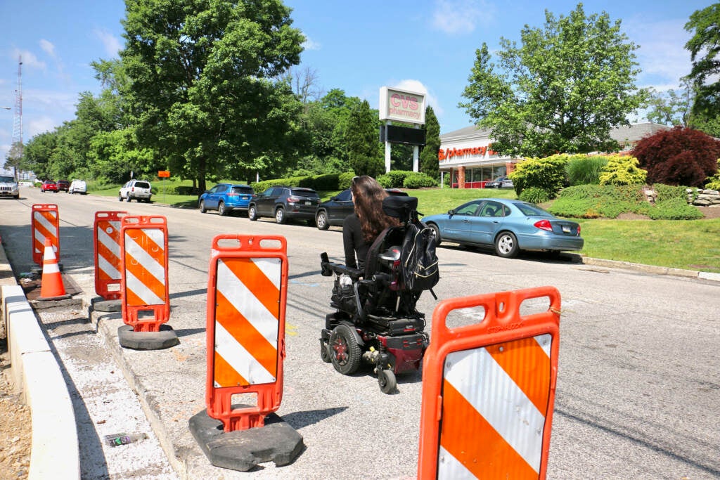 Anomie Fatale rides her wheelchair past road work