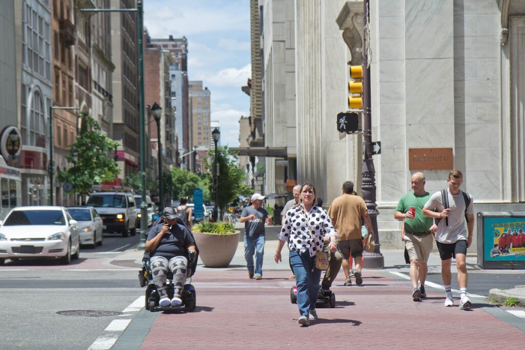 People crossing the street in a crosswalk, including some in wheelchairs