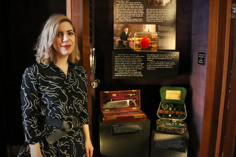 A woman stands next to a display exhibit.