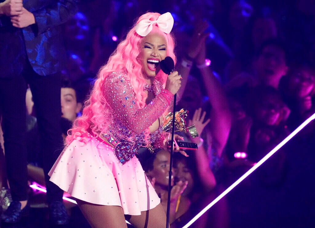 Nicki Minaj speaks into a microphone.