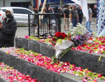 Flowers are shown at a memorial