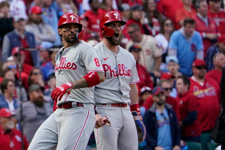 Philadelphia Phillies' Nick Castellanos (8) and Bryce Harper (3) celebrate after scoring on a single by Jean Segura during the ninth inning in Game 1 of a National League wild-card baseball playoff series against the St. Louis Cardinals, Friday, Oct. 7, 2022, in St. Louis. (AP Photo/Jeff Roberson)