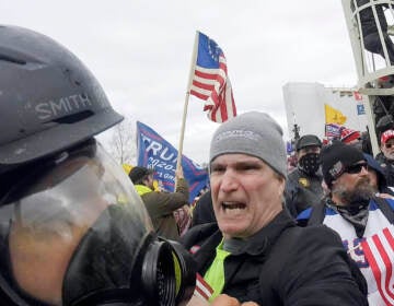 File: In this image from video, Alan William Byerly (center) attacks an Associated Press photographer during a riot at the U.S. Capitol in Washington, Jan. 6, 2021. On Sunday, Oct. 9, 2022, federal prosecutors recommended a prison sentence of nearly four years for Byerly, of Pennsylvania, who pleaded guilty to assaulting the AP photographer and using a stun gun against police officers during a mob's attack on the U.S. Capitol. (AP Photo/Julio Cortez, File)