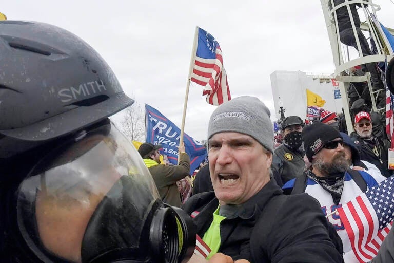 File: In this image from video, Alan William Byerly (center) attacks an Associated Press photographer during a riot at the U.S. Capitol in Washington, Jan. 6, 2021. On Sunday, Oct. 9, 2022, federal prosecutors recommended a prison sentence of nearly four years for Byerly, of Pennsylvania, who pleaded guilty to assaulting the AP photographer and using a stun gun against police officers during a mob's attack on the U.S. Capitol. (AP Photo/Julio Cortez, File)