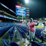 Fans leave Citizens Bank Park before Game 3 of baseball's World Series between the Houston Astros and the Philadelphia Phillies on Monday, Oct. 31, 2022, in Philadelphia. The game was postponed by rain Monday night with the matchup tied 1-1. (AP Photo/Matt Rourke)