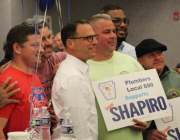 Democratic gubernatorial candidate Josh Shapiro posed for photos with some of his supporters while making an appearance in Philadelphia on Oct. 11, 2022. (Cory Sharber/WHYY)