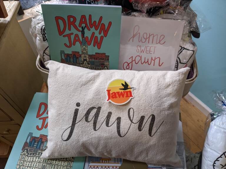 Pictured items include a jawn pillow from The Pillow Works, the Drawn Jawn coloring book by Katie Otte, a jawn sticker from South Fellini and a print that says 