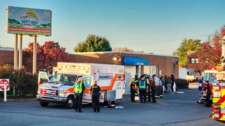 An ambulance is parked outside of a brick building.