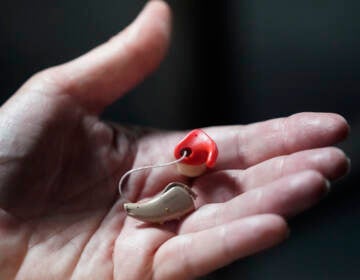 Chelle Wyatt holds her hearing aid on April 15, 2022, in Salt Lake City.
(Rick Bowmer/AP)