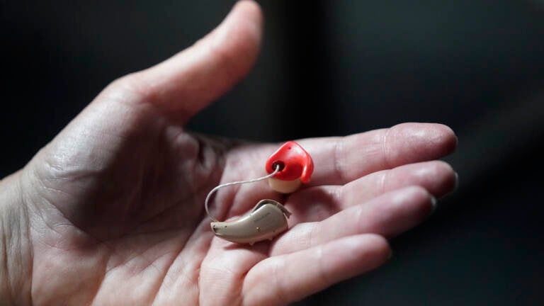 Chelle Wyatt holds her hearing aid on April 15, 2022, in Salt Lake City.
(Rick Bowmer/AP)