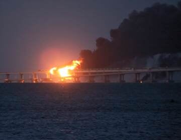 Flame and smoke rise from the bridge connecting the Russian mainland and the Crimean peninsula early Saturday. (AP)