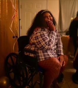 Briana Hickman gestures while smiling for a photo, sitting in her wheelchair