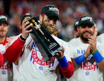 Bryce Harper holds up a trophy after the Phillies win the NLCS