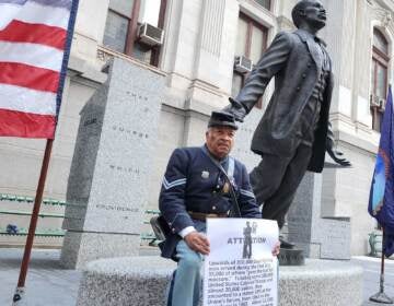 Robert Fuller Houston of the 3rd Regiment sits by the Catto statue at City Hall on Oct. 10, 2022. (Tom MacDonald/WHYY)