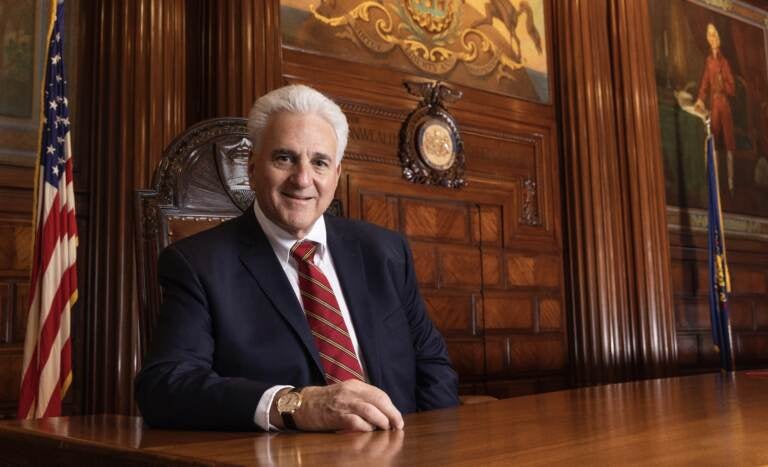 Chief Justice Max Baer sits at a wood table with the U.S. flag in the background.