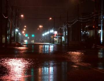 A flooded roadway is shown at night.