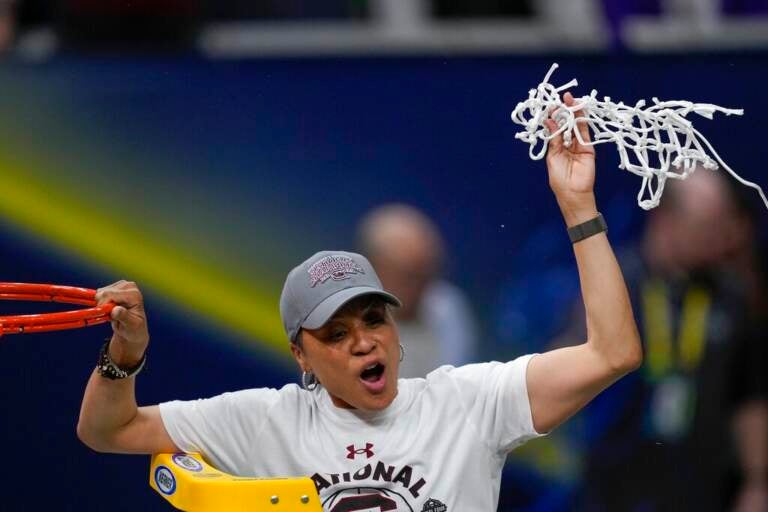 Dawn Staley holds up the net cut from the basketball hoop.