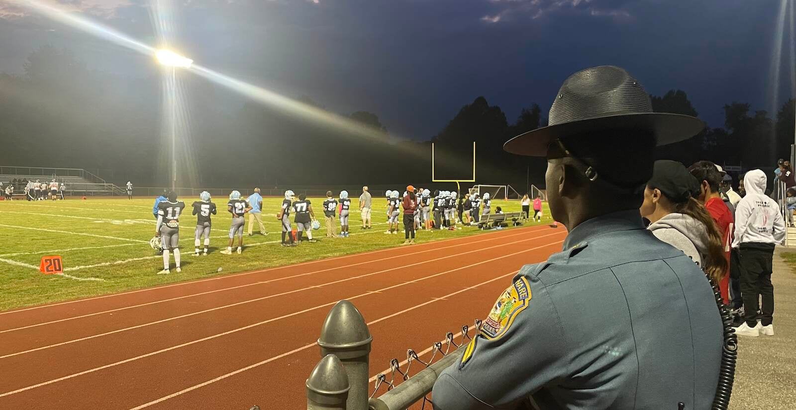 One of the three state troopers at the game watches the action. (Cris Barrish/WHYY)