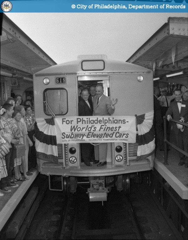 A group of people pose on a subway car.