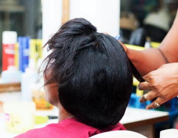 A woman has her hair chemically straightened at a salon