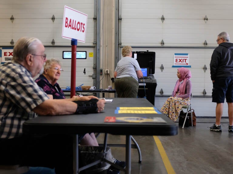 Poll workers sit at a check-in table.